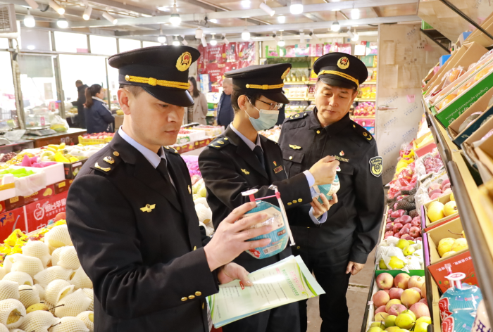 图为武清区市场监管局执法人员在农贸市场检查
是否在保质期内。